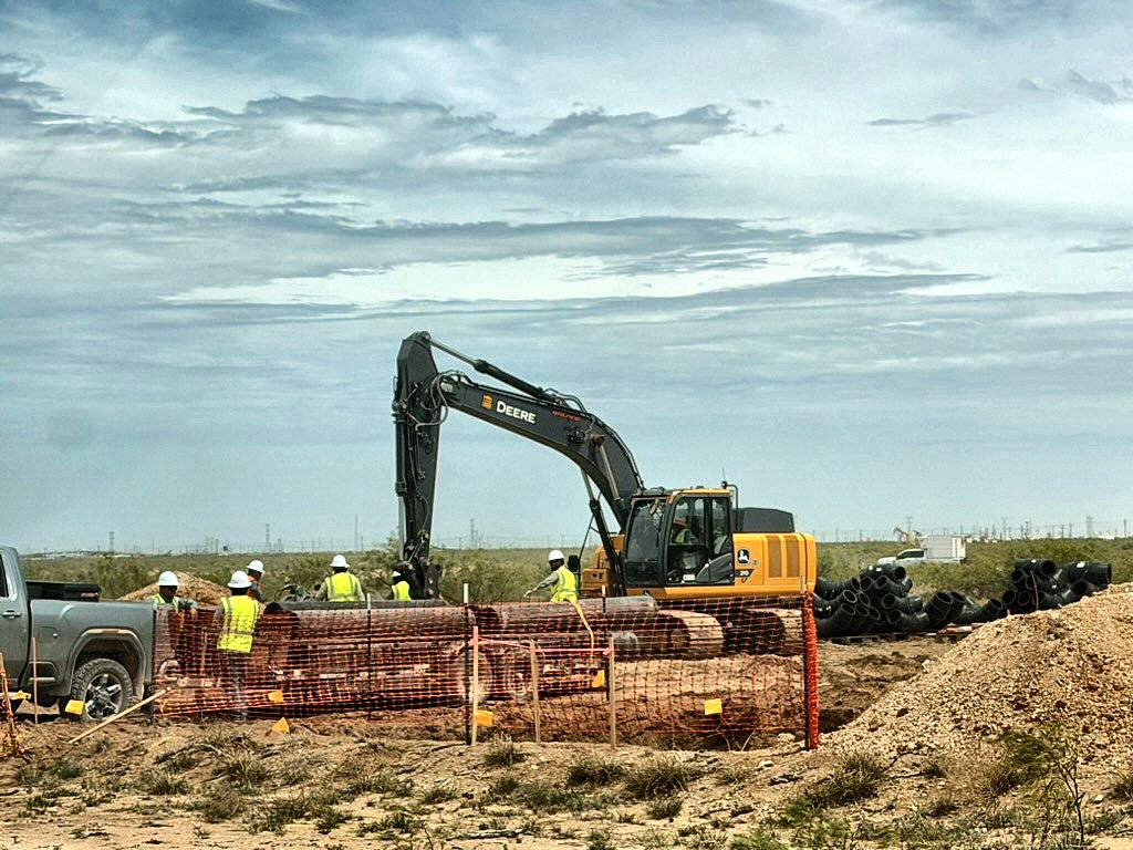 Encore crew and excavator at a fenced pipeline excavation with HDPE fittings