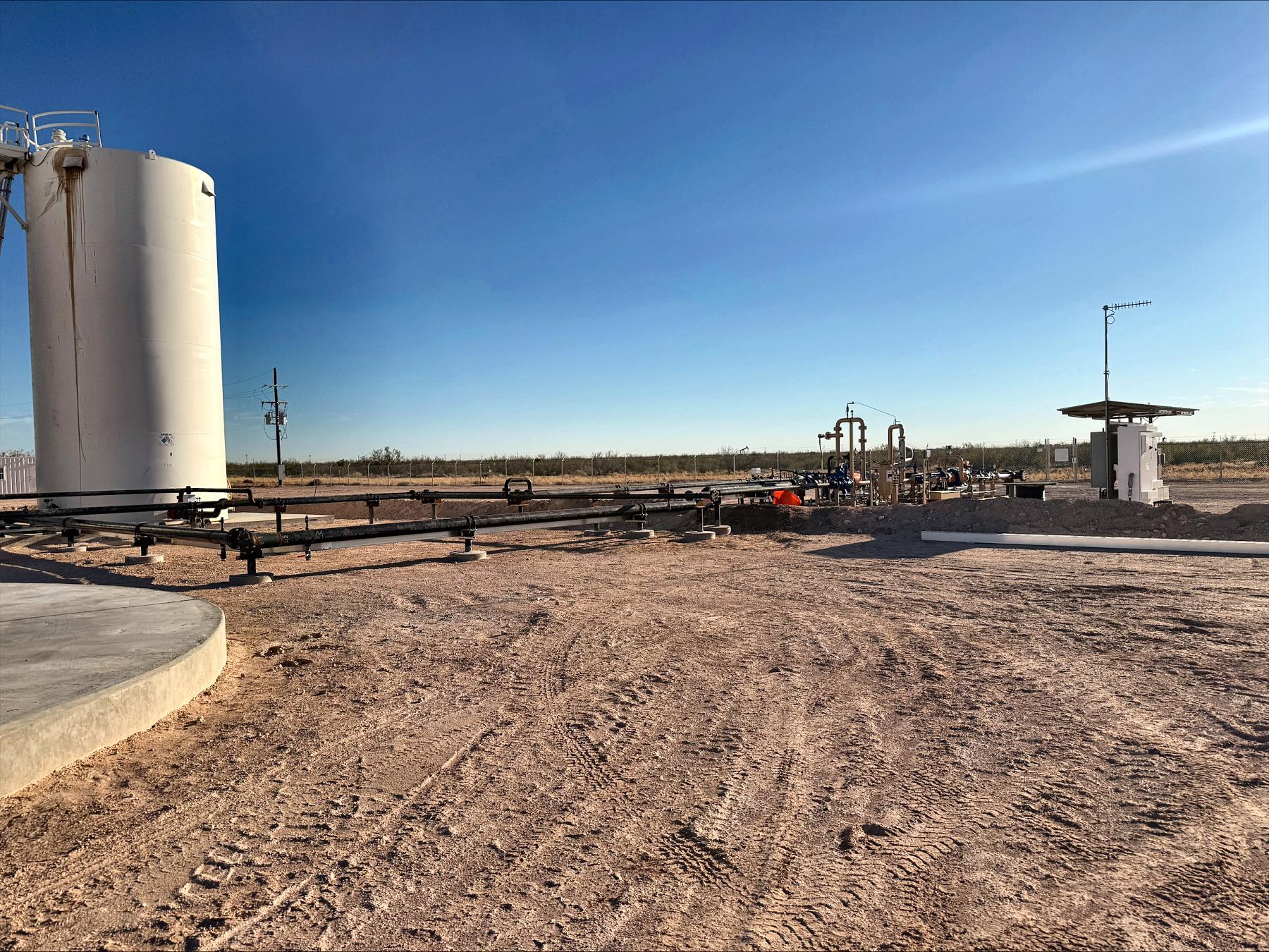 Central tank battery and gathering header on a West Texas lease with pump jacks nearby